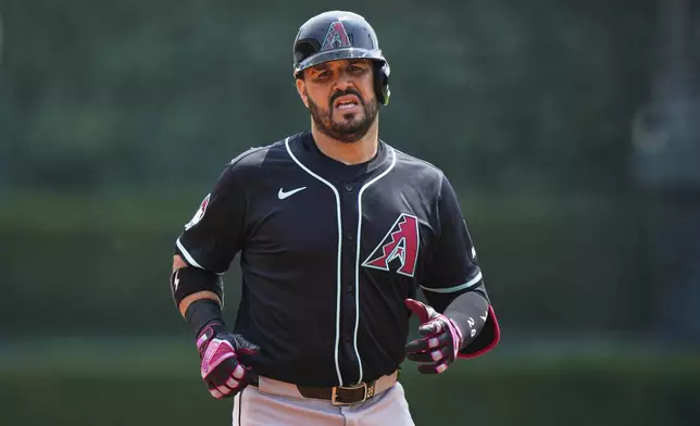 Arizona Diamondbacks designated hitter Eugenio Suarez runs back to the dugout after flying out to Detroit Tigers right fielder Kerry Carpenter during the second inning of a baseball game, Wednesday, July 30, 2025, in Detroit. (AP Photo/Ryan Sun)