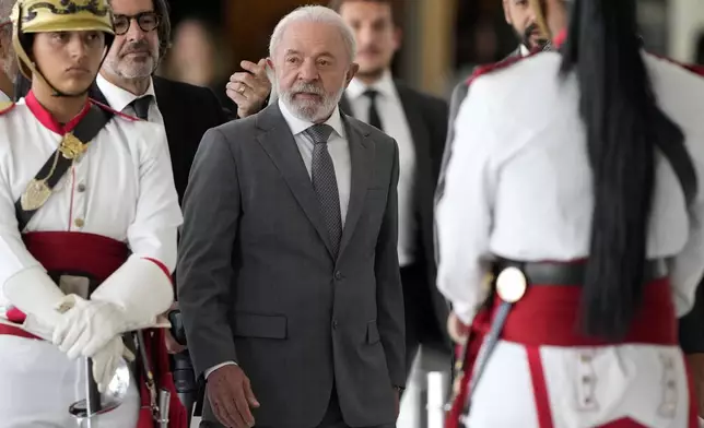 Brazil's President Luiz Inacio Lula da Silva walks among presidential guards during an event at the Planalto presidential palace in Brasilia, Brazil, Wednesday, July 9, 2025. (AP Photo/Eraldo Peres)