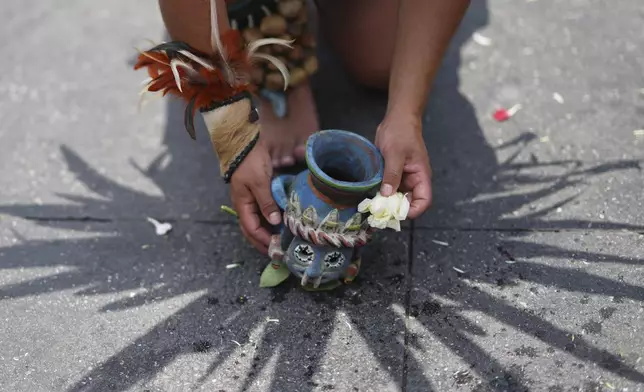 An artist in Indigenous clothing performs marking the 700th anniversary of the founding of Tenochtitlan, known today as Mexico City, in the capital's main square, the Zocalo, Saturday, July 26, 2025. (AP Photo/Eduardo Verdugo)