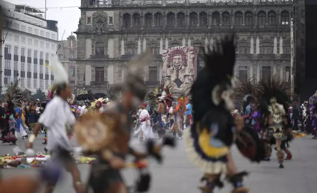 Dancers dressed in Indigenous clothing, backdropped by an image of Aztec goddess Tlaltecuhtli, gather to mark the 700th anniversary of the founding of Tenochtitlan, known today as Mexico City, in the capital's main square, the Zocalo, Saturday, July 26, 2025. (AP Photo/Eduardo Verdugo)