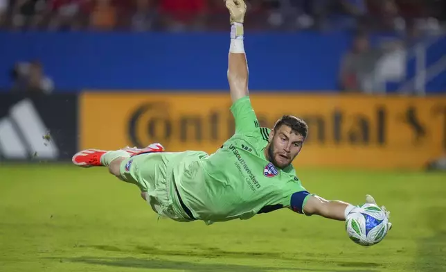 FC Dallas goalkeeper Maarten Paes makes a diving stop on a shot by New York City FC during the second half of an MLS soccer match Friday, July 25, 2025, in Frisco, Texas. (AP Photo/Julio Cortez)