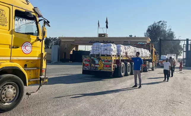 Trucks carrying humanitarian aids enter the Rafah crossing between Egypt and the Gaza Strip, Sunday, July 27, 2025. (AP Photo/Mohamed Arafat)