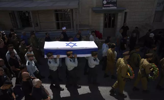 Israeli soldiers carry the coffin of Druze Israeli captain Amir Saad who was killed in a battle in the Gaza Strip, during his funeral in the village of Yanuh Jat, northern Israel, Sunday, July 27, 2025. (AP Photo/Ariel Schalit)