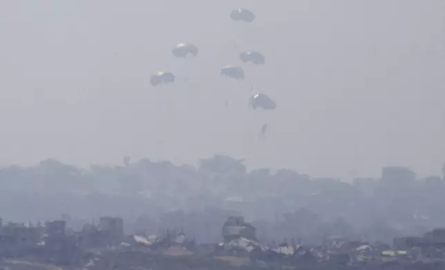 Humanitarian aid is airdropped to Palestinians over Gaza City, as seen from southern Israel, Sunday, July 27, 2025. (AP Photo/Ohad Zwigenberg)