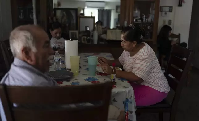 Ricarda Toledo eats her late lunch next to her husband, Agustin, at their mobile home in Oasis, Calif., Wednesday, Oct. 30, 2024. (AP Photo/Jae C. Hong)