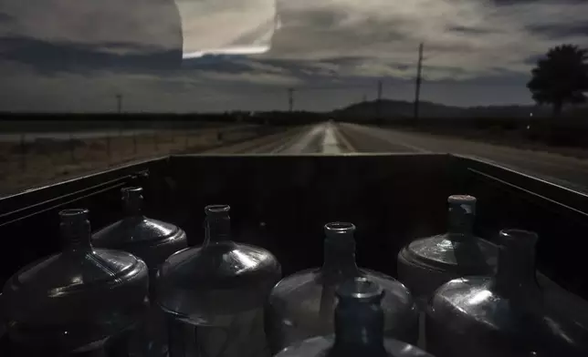 Empty water jugs sit in the bed of a pickup truck as Agustin Toledo and his wife, Ricarda, mobile home residents in Southern California's eastern Coachella Valley, travel to a nearby water store to refill them in Oasis, Calif., Wednesday, Oct. 30, 2024. (AP Photo/Jae C. Hong)