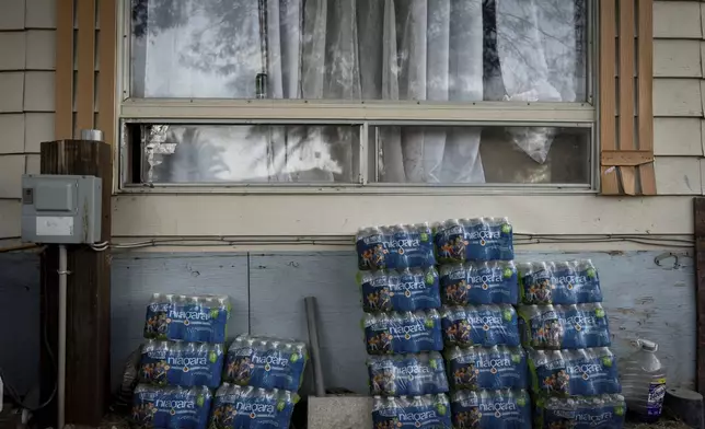 Cases of bottled water, provided by the mobile home park owner, are stacked outside a home in Oasis, Calif., Wednesday, Oct. 30, 2024. (AP Photo/Jae C. Hong)