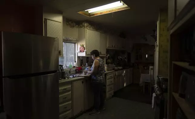 Maria de Jesus Galarza prepares dinner in her mobile home in Oasis, Calif., Wednesday, Oct. 30, 2024. (AP Photo/Jae C. Hong)