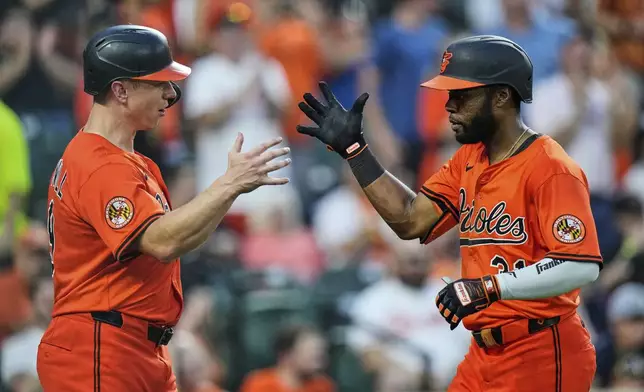 Baltimore Orioles' Cedric Mullins, right, celebrates with Tyler O'Neill, left, after hitting a three-run home run during the fourth inning of a baseball game against the Colorado Rockies, Saturday, July 26, 2025, in Baltimore. (AP Photo/Stephanie Scarbrough)