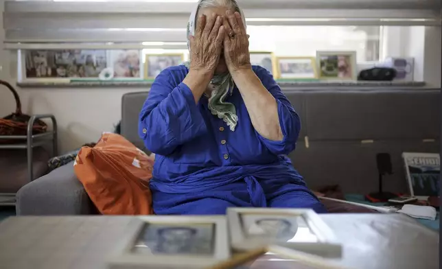 Suhra Malic, 89, mourns while looking at the pictures of her two sons, victims of the Srebrenica genocide, in a nursing home in the village of Potocari near Srebrenica, Bosnia, on June 29, 2025. During the genocide a total of 20 members of her family were killed. (AP Photo/Armin Durgut)