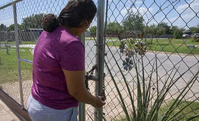 Terrified of being taken away from her children by ICE agents or police, Maria has begun locking her fence with a chain and padlock, Wednesday, June 18, 2025, at her home in Hidalgo County, Texas. (AP Photo/Jacquelyn Martin)