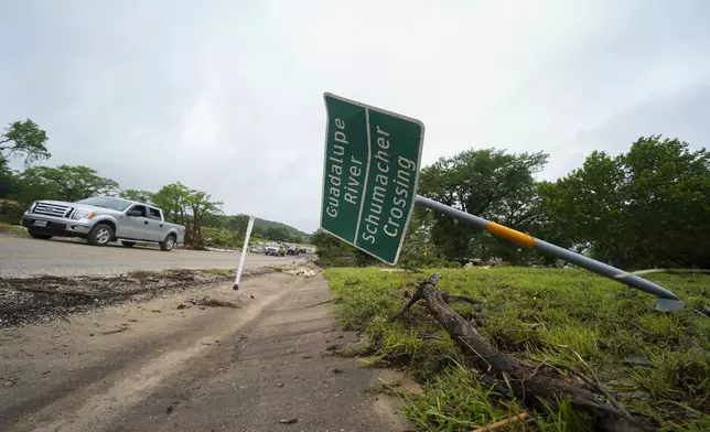 A downed sign is seen near a crossing of the Guadalupe River after a flash flood swept through the area Saturday, July 5, 2025, in Ingram. (AP Photo/Julio Cortez)