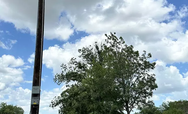 Comfort, Texas, Assistant Fire Chief, Danny Morales stands under a flash flood siren in the community's park on Thursday, July 10, 2025. (AP Photo/Sean Murphy)