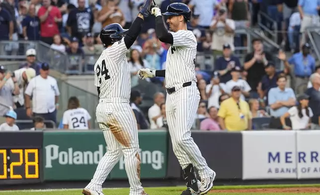 New York Yankees' Cody Bellinger, right, celebrates after hitting a home run during the third inning of a baseball game against the Chicago Cubs, Friday, July 11, 2025, in New York. (AP Photo/Yuki Iwamura)