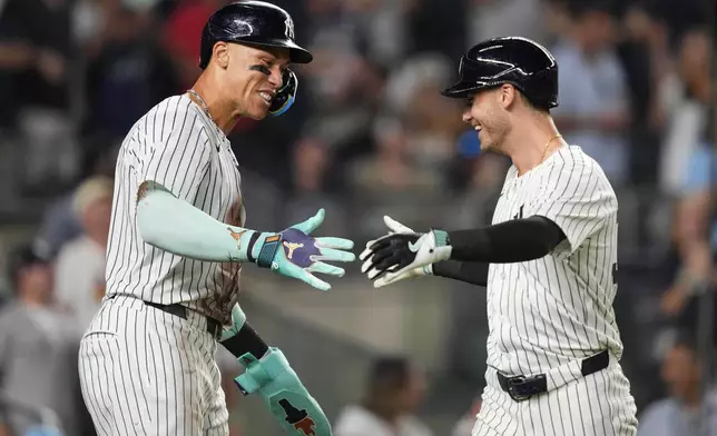 New York Yankees' Cody Bellinger, right, celebrates with Aaron Judge, left, after hitting a home run during the eighth inning of a baseball game against the Chicago Cubs, Friday, July 11, 2025, in New York. (AP Photo/Yuki Iwamura)