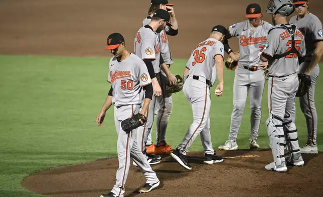 Baltimore Orioles starting pitcher Charlie Morton (50) leaves the mound after getting pulled by interim manager Tony Mansolino (36) during the sixth inning of a baseball game against the Tampa Bay Rays, Friday, July 18, 2025, in Tampa, Fla. (AP Photo/Phelan M. Ebenhack)