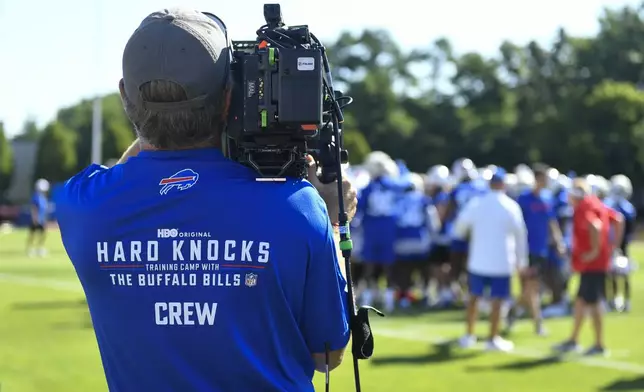 An NFL Films Hard Knocks cameraman films the Buffalo Bills during practice at the team's NFL football training camp, Wednesday, July 23, 2025, in Pittsford, N.Y. (AP Photo/Adrian Kraus)
