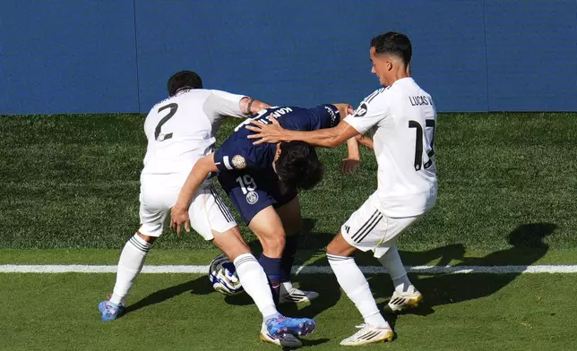 Real Madrid's Dani Carvajal (2) and Lucas Vazquez (17) compete against Paris Saint-Germain's Lee Kang-in (19) for control of the ball during the Club World Cup semifinal soccer match between PSG and Real Madrid in East Rutherford, N.J., Wednesday, July 9, 2025. (AP Photo/Pamela Smith)