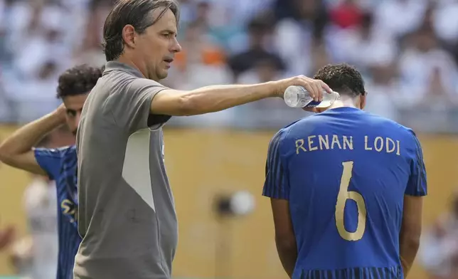 FILE - Al-Hilal manager Simone Inzaghi, left, uses water to cool down his player Renan Lodi during the Club World Cup group H soccer match between Real Madrid and Al Hilal in Miami, Fla., Wednesday, June 18, 2025. (AP Photo/Lynne Sladky, File)