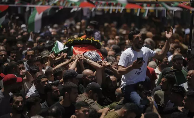 Mourners carry the bodies of Palestinian-American Sayfollah Musallet, 20, and Mohammed al-Shalabi during their funeral in the West Bank village of Al-Mazraa a-Sharqiya on Sunday, July 13, 2025. According to the Palestinian Health Ministry, Musallet was killed in an attack by Israeli settlers and al-Shalabi was shot in the chest. (AP Photo/Leo Correa)