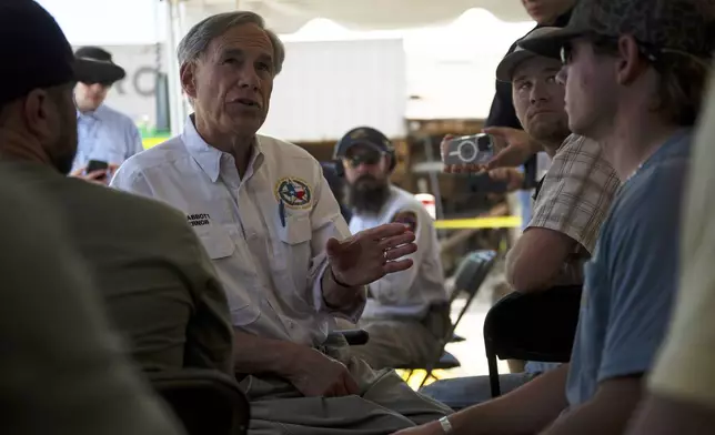 Texas Gov. Greg Abbott speaks to residents and volunteers before a press conference on Tuesday, July 8, 2025, in Hunt, Texas. (AP Photo/Eli Hartman)