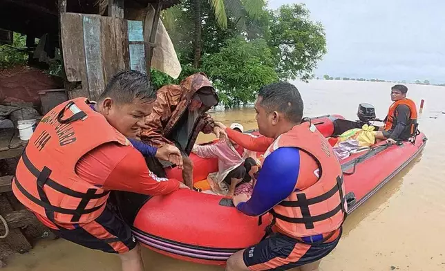In this photo provided by the Philippine Coast Guard, rescuers assist a man to a rubber boat as they bring him to safer grounds following floods in Mamburao, Occidental Mindoro province, Philippines on Wednesday July 23, 2025. (Philippine Coast Guard via AP)3