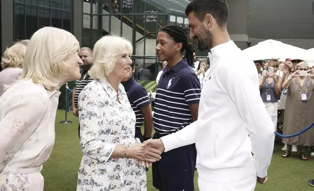 Britain's Queen Camilla, left, Charles, shakes hands with Novak Djokovic at the All England Lawn Tennis and Croquet Club on day ten of the 2025 Wimbledon Championships, Wednesday July 9, 2025. (Jordan Pettitt/PA via AP, Pool)