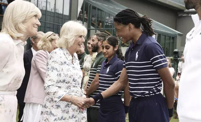 Britain's Queen Camilla, left, Charles, speaks with ball boy Karsten at the All England Lawn Tennis and Croquet Club on day ten of the 2025 Wimbledon Championships, Wednesday July 9, 2025. (Jordan Pettitt/PA via AP, Pool)