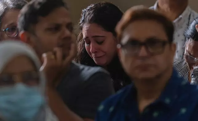 A relative of the crew of the Air India flight that crashed in Ahmedabad last month, mourns during a prayer meeting at a church in Mumbai, India, Saturday, July 12, 2025. (AP Photo/ Rafiq Maqbool)