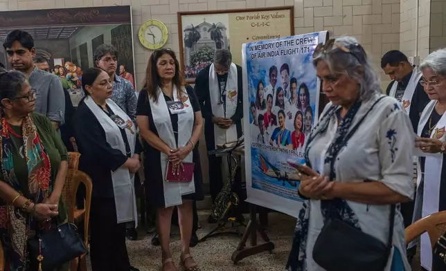 People offer prayers for crew members of the Air India flight that crashed in Ahmedabad last month during a prayer meeting at a church in Mumbai, India, Saturday, July 12, 2025. (AP Photo/ Rafiq Maqbool)