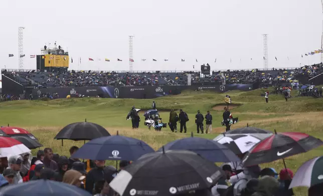 A general view of the 18th green as a group of players including Lee Westwood of England walk to the green during the first round of the British Open golf championship at the Royal Portrush Golf Club, Northern Ireland, Thursday, July 17, 2025. (AP Photo/Peter Morrison)