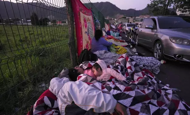 Neighbors remain outside their homes after dozens of earthquakes and aftershocks were recorded in a matter of hours in Palin, Guatemala, early Wednesday, July 9, 2025. (AP Photo/Moises Castillo)