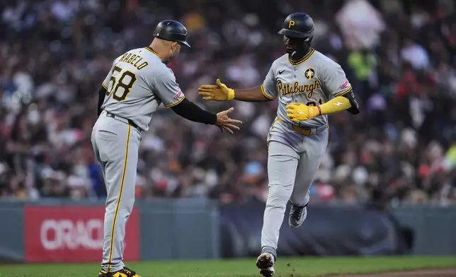 Pittsburgh Pirates' Liover Peguero, right, celebrates with third base coach Mike Rabelo after hitting a solo home run during the fifth inning of a baseball game against the San Francisco Giants, Tuesday, July 29, 2025, in San Francisco. (AP Photo/Godofredo A. Vásquez)