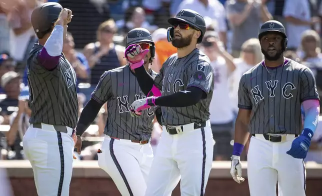 New York Mets' Brandon Nimmo celebrates his grand slam with the scorers, Pete Alonso, Fransisco Lindor and Starling Marie, during the first inning of a baseball game against the New York Yankees, Saturday, July 5, 2025, in New York. (AP Photo/Angelina Katsanis)