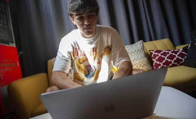 Bruce Perry, 17, demonstrates using artificial intelligence software on his laptop during a break from summer camp Tuesday, July 15, 2025, in Russellville, Ark. (AP Photo/Katie Adkins)