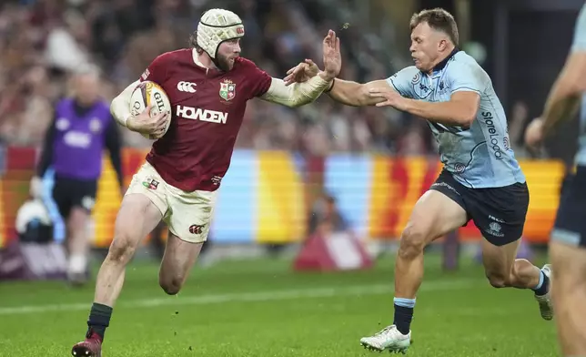 Mack Hansen of the British &amp; Irish Lions attempts veto beat the tackle of Waratahs' Darby Lancaster, right, during the Lions and Waratahs rugby match in Sydney, Australia, Saturday, July 5, 2025. (AP Photo/Mark Baker)
