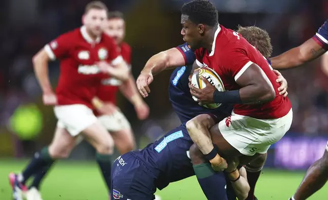 Maro Itoje of the British &amp; Irish Lions is tackled by a defender during their game against the Queensland Reds in Brisbane, Australia, Wednesday, July 2, 2025. (AP Photo/Pat Hoelscher)
