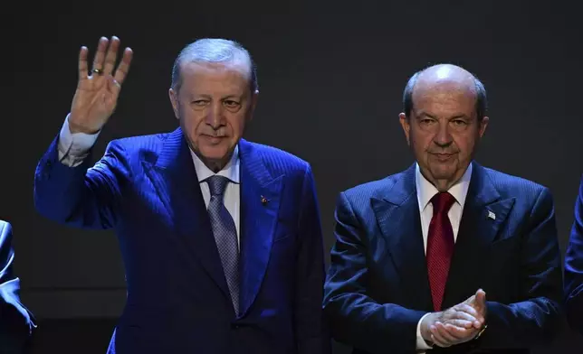 Turkish President Recep Tayyip Erdogan, left, waves during a meeting with Turkish Cypriot leader Ersin Tatar before a military parade marking the 51st anniversary of the 1974 Turkish invasion in the Turkish occupied area of the divided capital Nicosia, Cyprus, in the divided capital of Nicosia, Sunday, July 20, 2025. (AP Photo/Nedim Enginsoy)