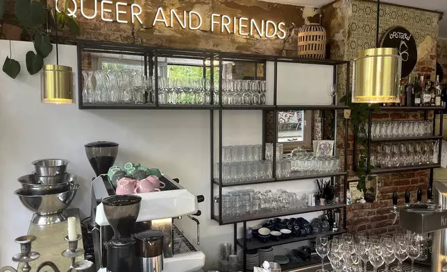 Interior view of the 'Das Hoven' cafe with a neon sign reading 'Queer And Friends' in Berlin, Germany, Thursday, July 31, 2025. (AP Photo/Fanny Brodersen)