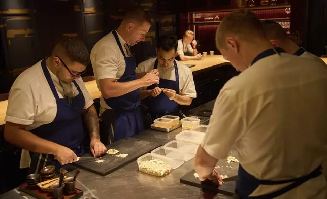 Executive chef Torsten Vildgaard, left center, and his staff chop nuts at FZN Restaurant on Palm Jumeirah in Dubai, United Arab Emirates, Friday, June 13, 2025. (AP Photo/ Fatima Shbair)