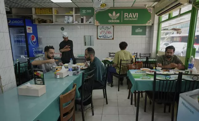 People dine at Ravi restaurant in Satwa district of Dubai, United Arab Emirates, Monday, June 9, 2025. (AP Photo/Altaf Qadri)