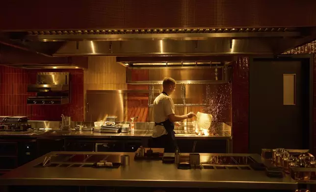 A chef lights charcoal at FZN Restaurant on Palm Jumeirah in Dubai, United Arab Emirates, Friday, June 13, 2025. (AP Photo/ Fatima Shbair)