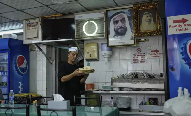A waiter carries Roti or flat breads at Ravi restaurant in Satwa district of Dubai, United Arab Emirates, Monday, June 9, 2025. (AP Photo/Altaf Qadri)