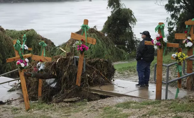 FILE - Rain falls as Irene Valdez visits a make-shift memorial for flood victims along the Guadalupe River, Sunday, July 13, 2025, in Kerrville, Texas. (AP Photo/Eric Gay, File)