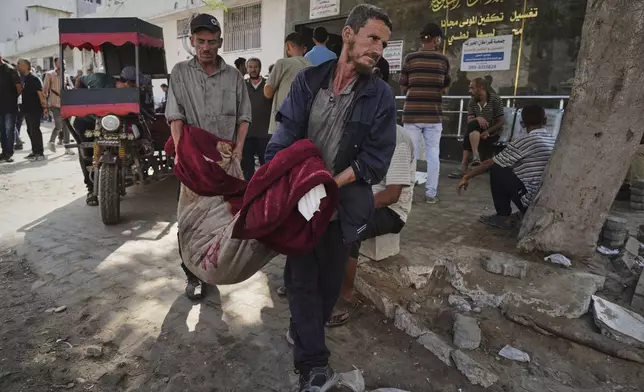 Palestinians carry the body of a person killed in an Israeli army airstrike on Gaza into Shifa Hospital in Gaza City on Tuesday, July 22, 2025. (AP Photo/Jehad Alshrafi)