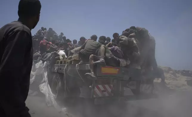 Palestinians hold onto an aid truck returning to Gaza City from the northern Gaza Strip on Tuesday, July 22, 2025. (AP Photo/Jehad Alshrafi)