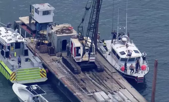 This image taken from video provided by WSVN-TV shows Miami-Dade Fire Rescue and others in boats around what appears to be a barge involved in an accident with a group of kids and an adult on a sailing boat during a sailing camp, Monday, July 28, 2025, in Miami. (WSVN-TV via AP)