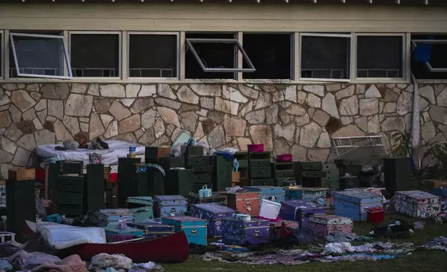 Campers belongings sit outside one of Camp Mystic's cabins near the Guadalupe River after a flash flood swept through the area Monday, July 7, 2025, in Hunt, Texas. (AP Photo/Eli Hartman)