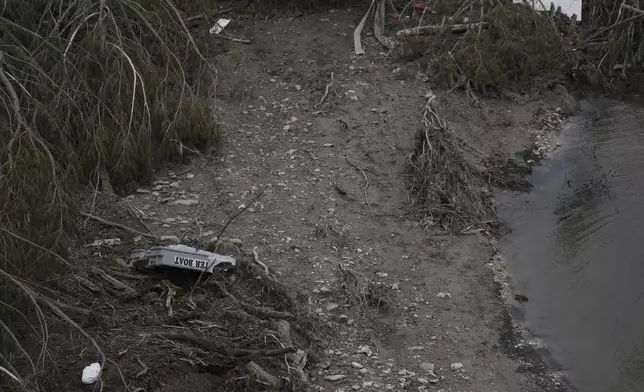 Debris is scattered by the river bed after flooding in Kerrville, Texas, Monday, July 7, 2025. (AP Photo/Ashley Landis)