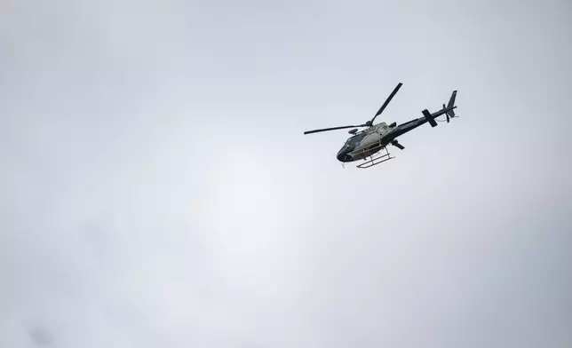 A rescue helicopter flies above a search and rescue site along the Guadalupe River after a flash flood swept through the area, Monday, July 7, 2025, in Ingram, Texas. (AP Photo/Eli Hartman)